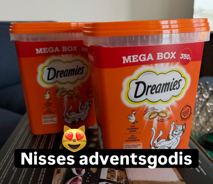 Två orangea Dreamies Mega Box-kartonger för kattgodis med texten "Nisses adventsgodis" och en emoji av en katt med hjärtögon.