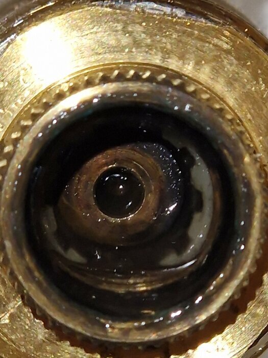 Närbild av en radiatorventil inifrån, visar ventilinsatsens komponenter med fokus på ventilkäglan och ventilhusets struktur.