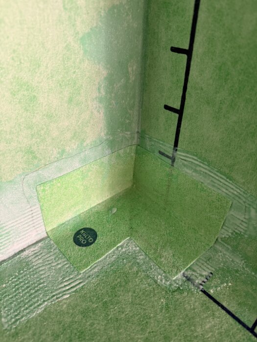 Grönt badrumshörn med monterat Kiilto Kerasafe system och synliga skarvar; diskussion om limstyrka och extra försegling med K2-lim över hörn.