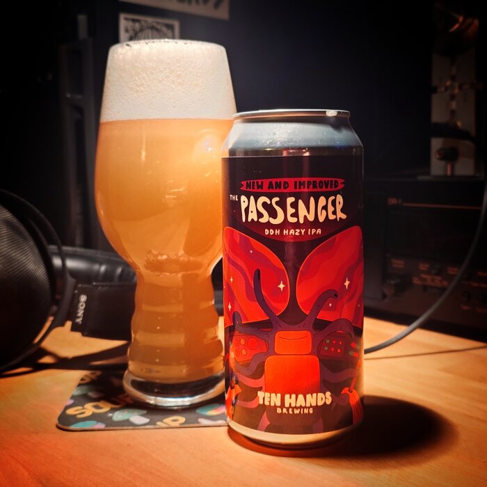 En burk med "The Passenger" DDH Hazy IPA från Ten Hands Brewing bredvid ett glas öl.