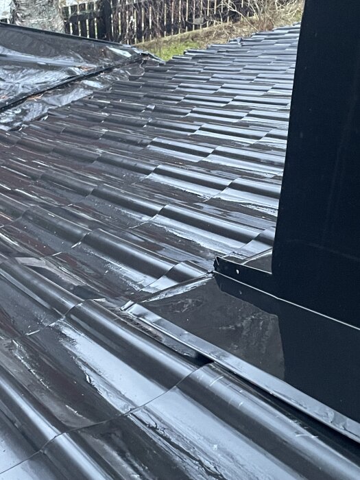 Plåttak med fuktskador nära ventilationshuv, hål synligt. Möjlig orsak till fuktproblem, besiktning och åtgärd övervägs.