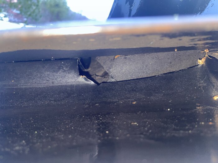 Hål i råsponten nära ventilationshuv på vinden under ett plåttak, möjligen orsaken till läckage eller fuktproblem enligt trådstartaren.