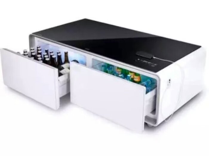 En kylbox-bord kombination med öppna lådor fyllda med ölflaskor och burkar, troligen i ett vardagsrum eller kök.