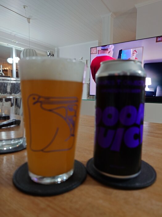 Ett glas med öl och en burk märkt "Doom Juice" av Amundsen på ett bord, med en TV i bakgrunden som visar människor i tomtedräkter.