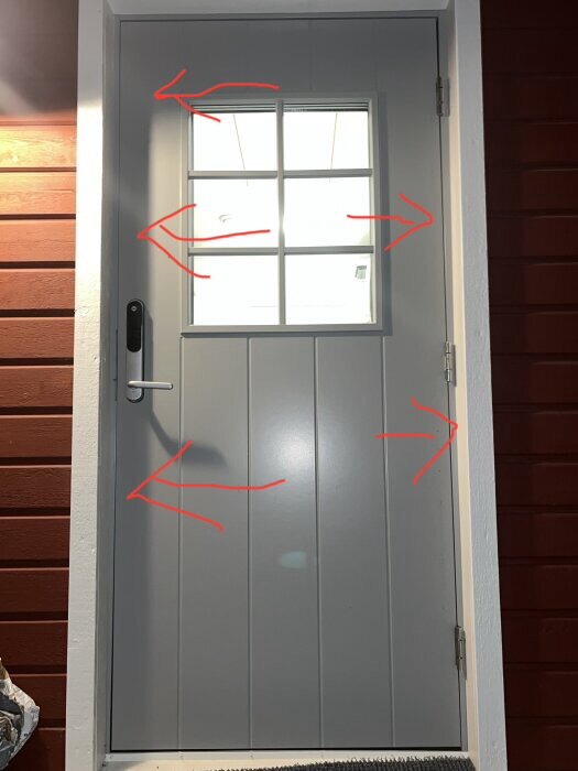 Dörr med markerade områden för skruvjustering för att förbättra dörrens passform och springa enligt rekommendationer, inklusive Yale dörrspringa.