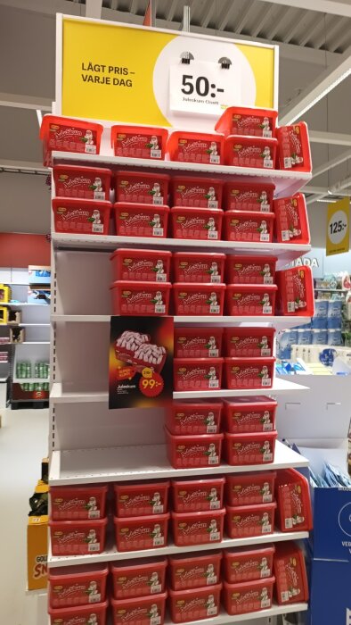Hylla i butik fylld med röda förpackningar av Juleskum från Cloetta, skylt om pris 50 kronor, lågpris varje dag.