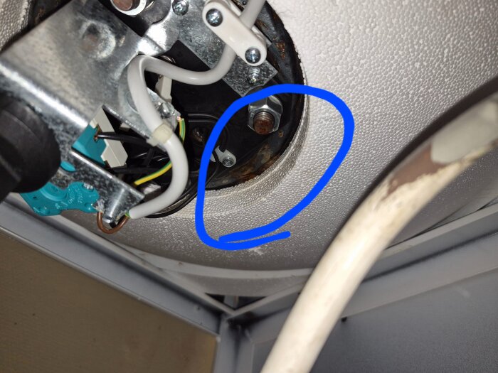 Rostfläck och läckage på undersidan av en Nibe Compact CU 200 varmvattenberedare, markerad med en blå cirkel.