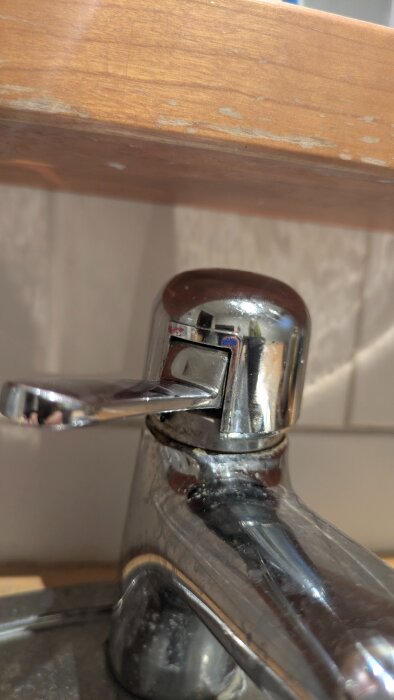 Bild på en silvrig badrumsblandare utan synlig låsskruv, som har problem med vattenflödet.