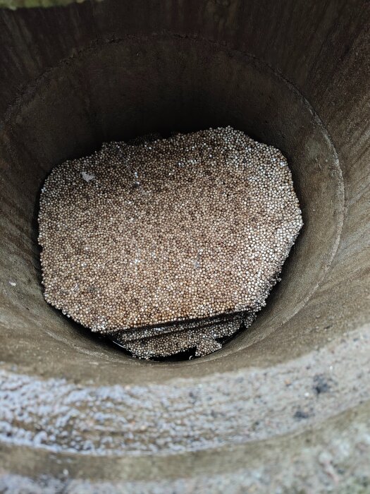 En öppen brunn fylld med frigolitkulor, vilket kan påverka vattnets kvalitet.