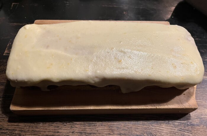 Rektangulär jultårta med saffran och apelsinsmörkräm på skärbräda.