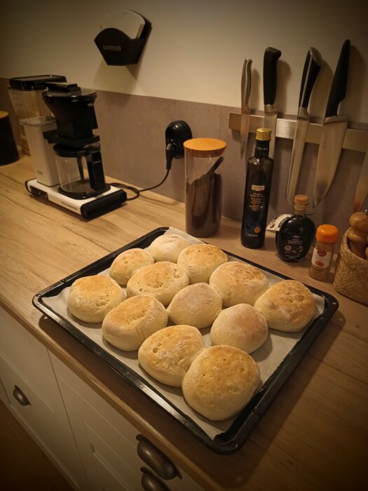 Färska källarfranskor på en plåt i köket, omgivna av köksredskap och ingredienser på bänken.