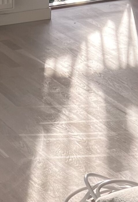 Ekparkettgolv med ljusgrå Osmo dekorvax och Osmo hårdvaxolja. Synliga små repor i solljus.