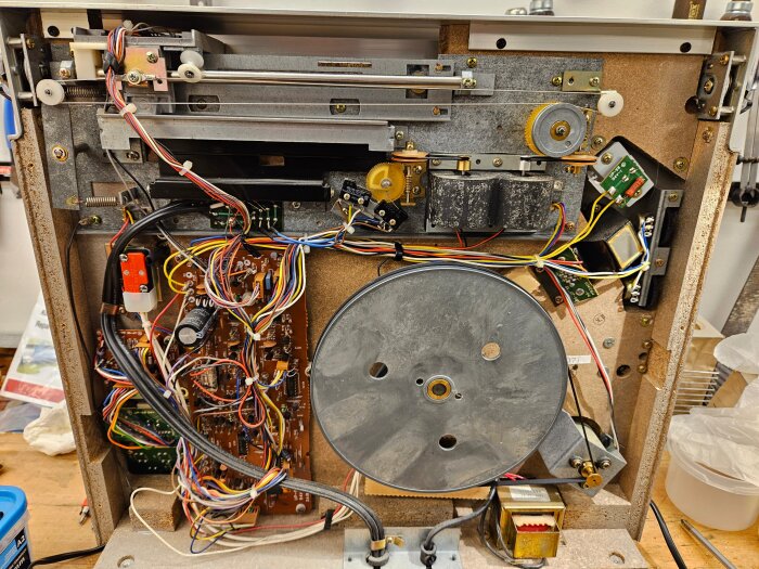 Inuti en stående tangentialspelare från 1981 med synliga kretsar, kablar och drivremmar efter renovering.