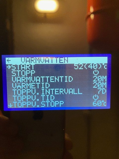 Display av Thermia Legend 10 Duo, visar menyer för att justera varmvattentemperaturen och inställningar, med aktuell starttemperatur på 52°C.
