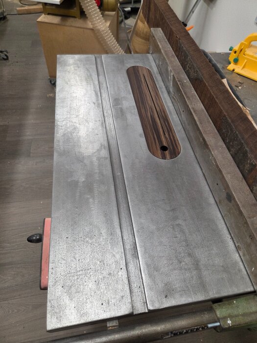 Såg med ny throat-plate gjord av peruansk valnöt, försedd med N42-neodymium magneter för stabilitet, placerad på ett arbetsbord i verkstad.