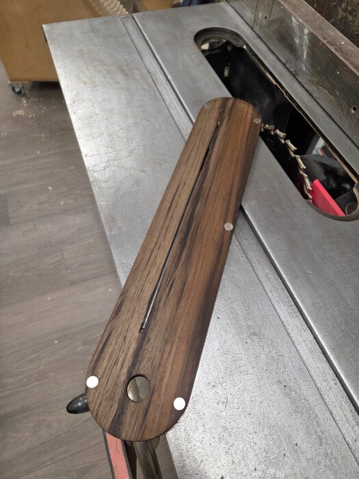 En bit peruansk valnöt fungerande som en ny throat-plate på en såg med inbäddade N42-neodymiummagneter för stabilisering.