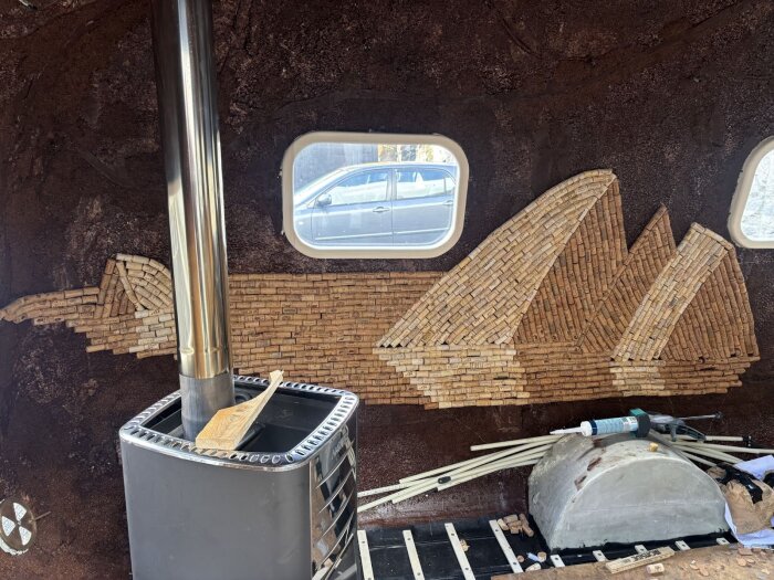 Korkväggsdesign med isbergsmönster mot en brun bakgrund inuti ett rum, med ett silverfärgat rör och fönster som bakgrund.