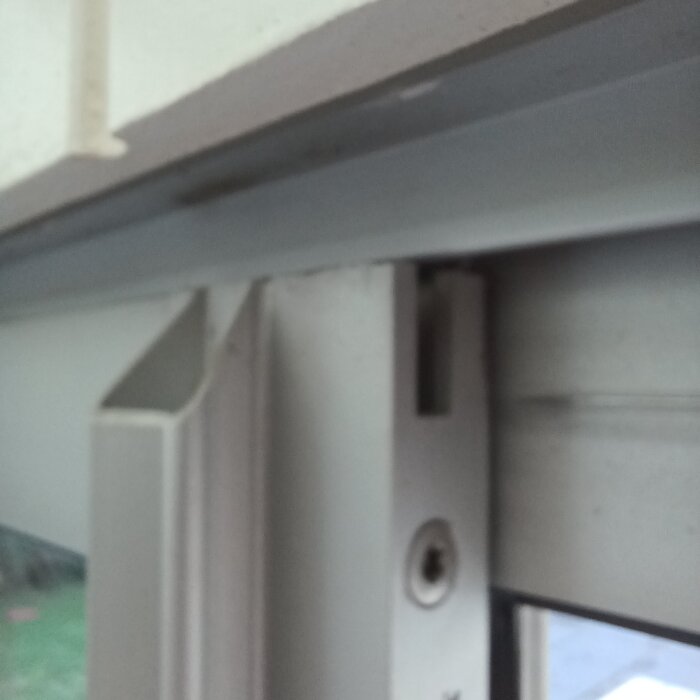 Närbild av en skjutdörrs övre del där den inte längre sitter korrekt i det övre spåret.