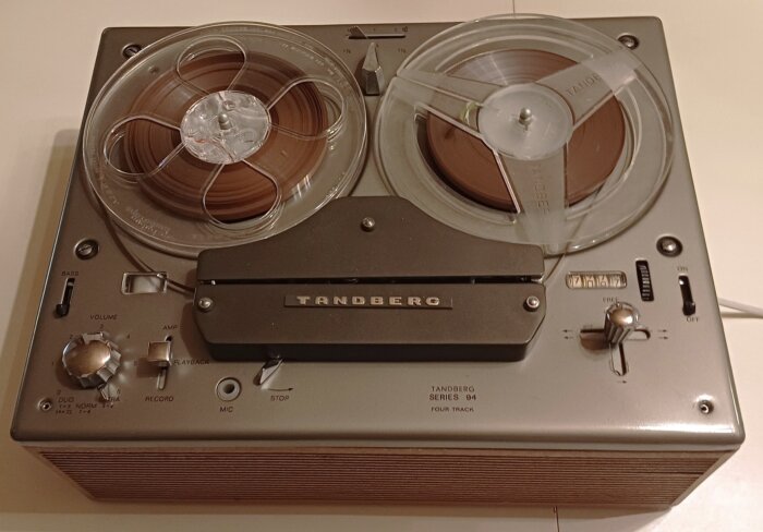 Tandberg rullbandspelare, toppmatad, med teakfanerade sidor, inspelnings- och uppspelningsfunktioner, nostalgisk klassrumsutrustning.