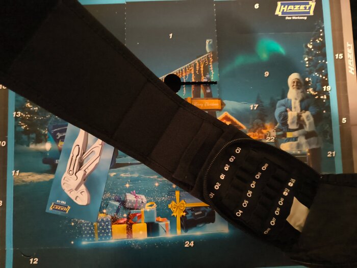 Verktygsväska med olika storlekar av fack visas ovanpå en adventskalender med tomte och presenter.