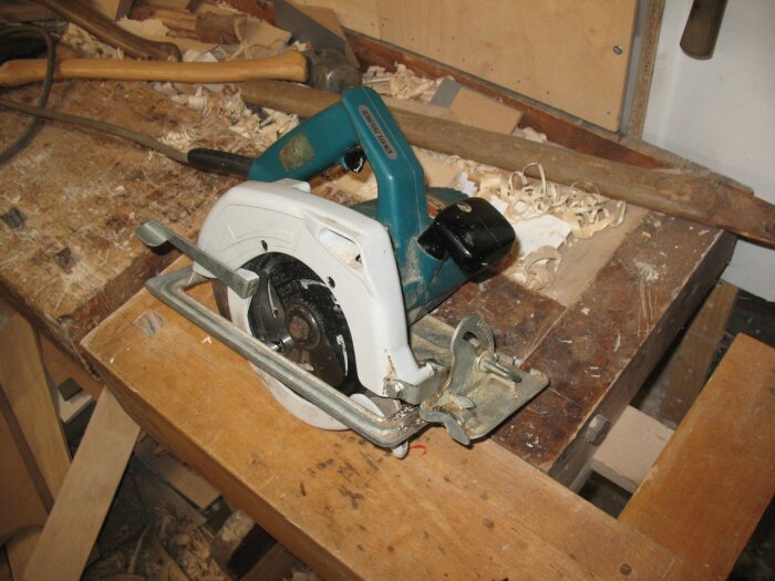 Återanvänd handcirkelsåg av märket Black&Decker på arbetsbänk med träspån i bakgrunden.
