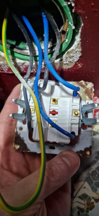 Elektriska ledningar med blå och gul/grön jordkabel i en eldosan i ett hushåll, jorden ej kopplad till eluttaget.