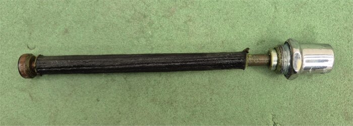 Krankägla och mekanism från utkastare, med ny krankägla utan upphöjd gummiring, på grön bakgrund.