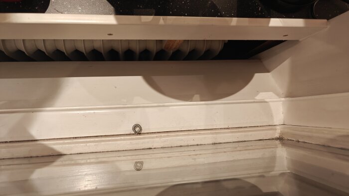 Inkökt med öppen nisch och synligt element bakom en vit sarg på 3 cm, beskrivs i inlägget som effektivt för att hindra saker från att falla ner.