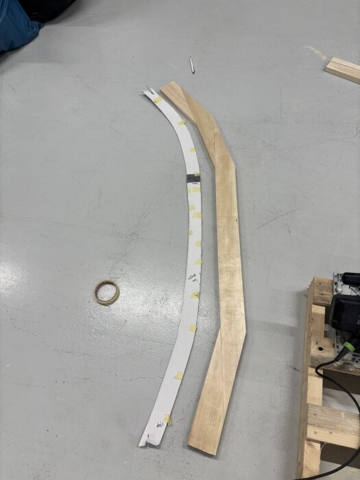 Mall i kartong och utsågad träbit placerade på golvet, användes för att skapa rätt kurvatur för en dörrkarm.