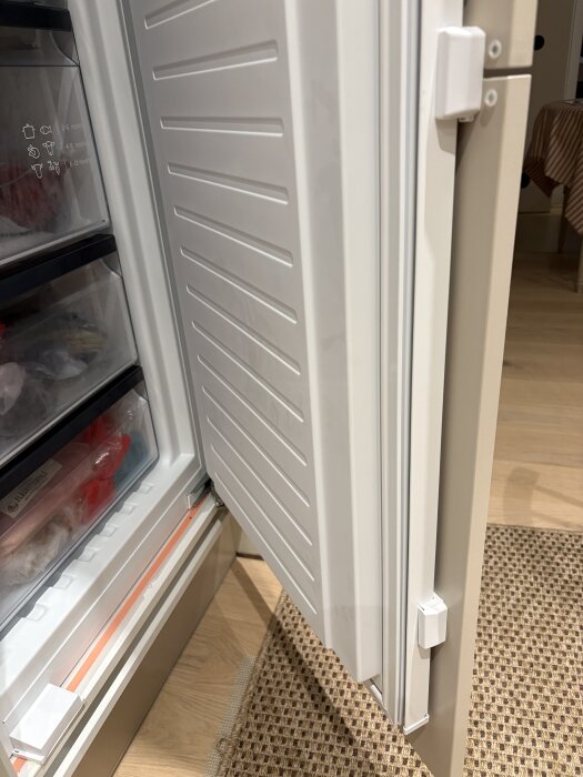 Kylskåpsdörr monterad med Marbodals plastanordning som ger rätt distans mellan sammanfogade dörrblad.