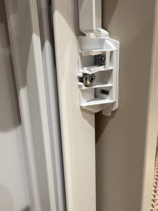 Transparent plastanordning med distans monterad på dörrblad intill kylskåpsdörr.