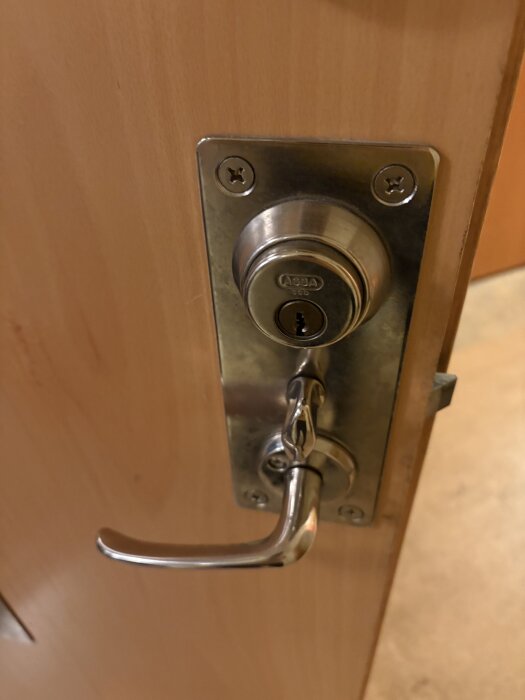 Slitet dörrhandtag och lås på en ytterdörr, handtaget är slappt och låset krånglar enligt inlägget.