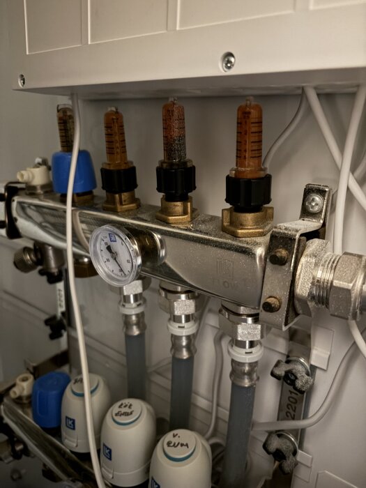 Installationsdetaljer av ett vattenrörsystem med flödesmätare och tryckmätare, inklusive ventiler och kopplingsdelar.