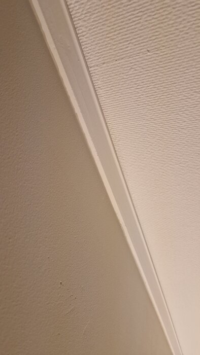 Vägg och tak med ny målad list, där grundfärg, fog och täckfärg applicerats enligt beskrivningen.