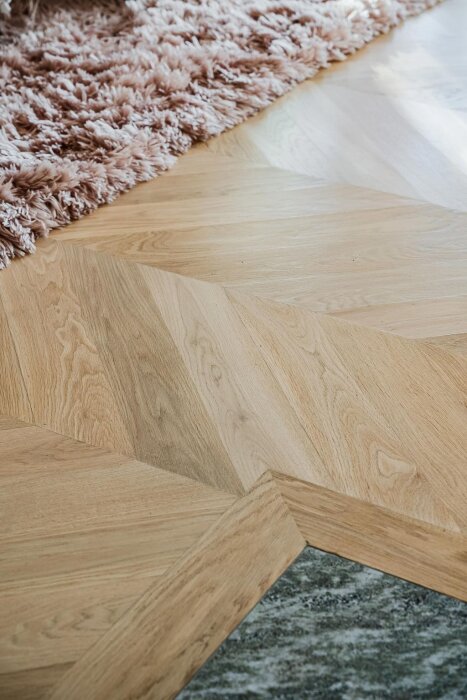 Trägolv möter stenyta med dragning av silikon mellan materialen.