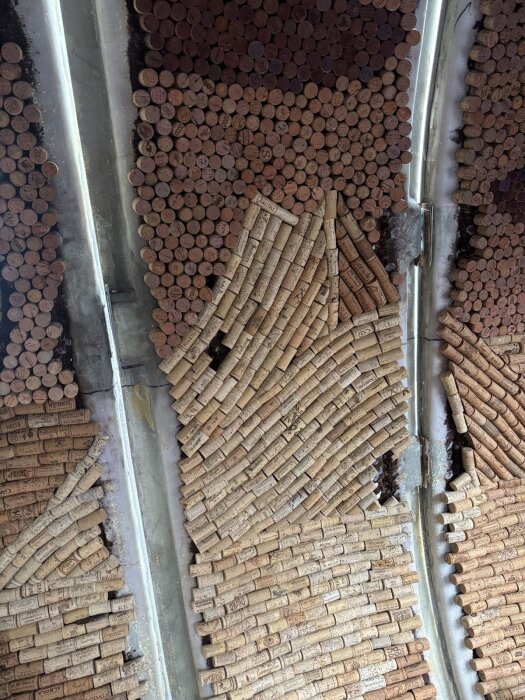 Korkproppar i varierande mönster ligger arrangerade tätt tillsammans på en yta, med några synliga skarvar och oregelbundna sektioner.