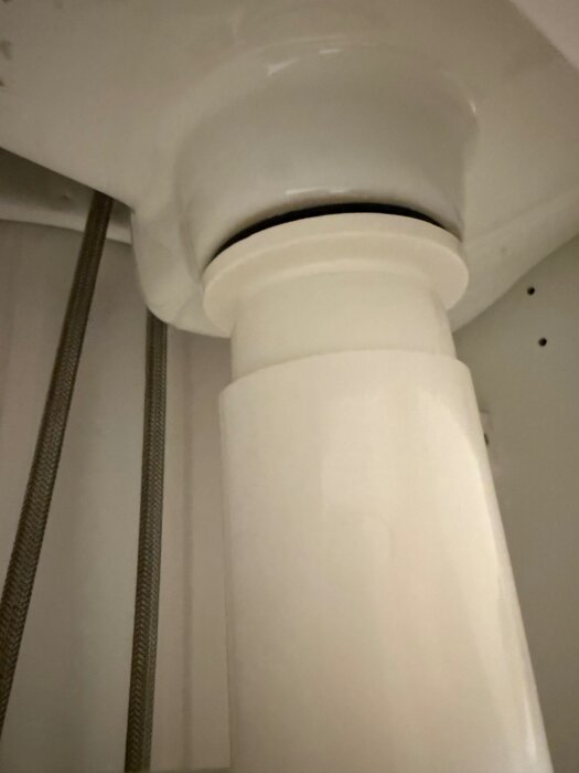 Underifrån bild av ett monterat Prevex vattenlås med synlig gummiring där vatten eventuellt sipprar ut.