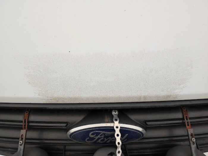 Fronten av en smutsig bil efter en misslyckad tvätt, Ford-logosynlig.