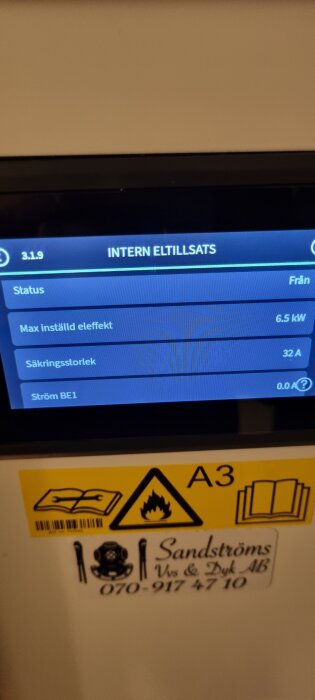 Display som visar värden för intern eltillsats i en värmepump: max effekt 6.5 kW, säkringsstorlek 32 A, aktuell ström 0.0 A. Säkerhetssymboler nedan.