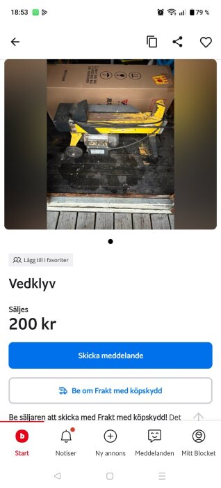 Gul vedklyv till salu, placerad på ett golv med en låda i bakgrunden. Pris: 200 kr.