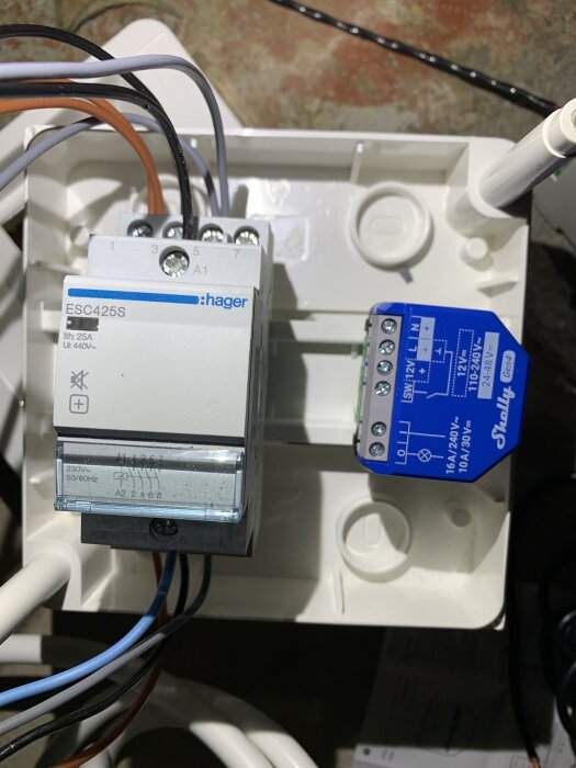 Elektrisk installation med relä och kopplingsdosor, flera färgade kablar anslutna.