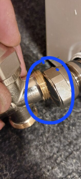 Anslutningar mellan två metallrör, den ena med blå markering runt en delvis skruvad koppling.