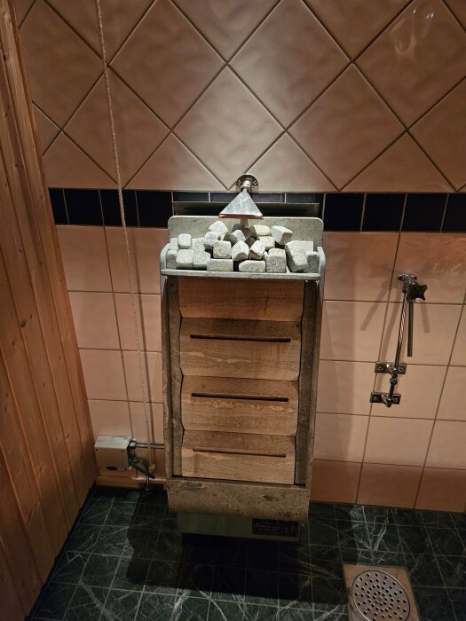 Bastuaggregat med stenar och kopplingar, del av ett moderniserat styrsystem med Arduino och SSR för exakt temperaturreglering.