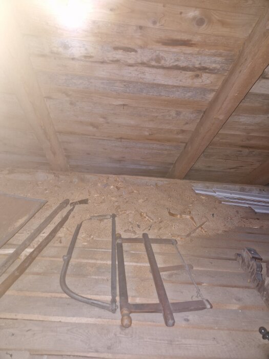 Trätak med synlig fuktgenomslag och mögel i en vind från ett hus byggt 1934, verktyg på golvet, relaterat till diskussion om takbyte och ventilation.