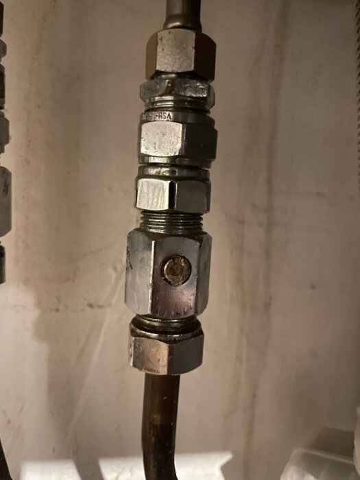 Kopparrör anslutet till kulventil med flera muttrar synliga, del av köksrenovering.