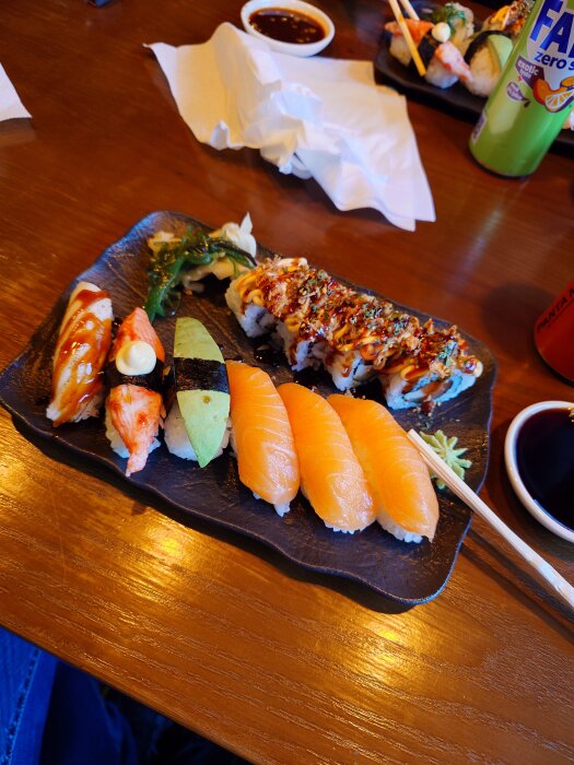Sushi tallrik med nigiri, maki och tillbehör på träbord vid Dala Sushi.