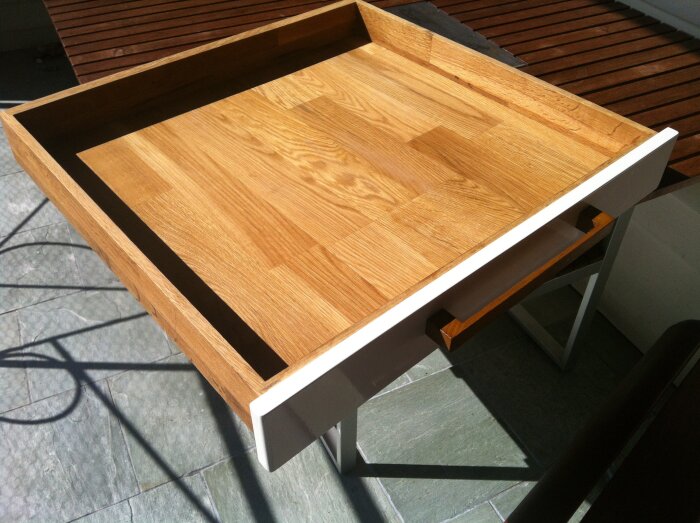 Träbord med upphöjd kant, delvis möjligen konstruerat för att underlätta träbearbetning eller för snickeriprojekt.