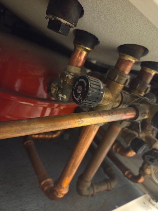 Rör och ventiler på en Nibe Fighter 310P frånluftvärmepump, med fokus på kopparrör och justeringsratt.