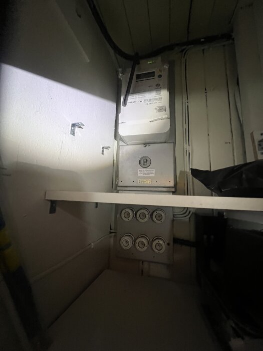 Elcentral med elmätare och säkringar installerade av Vattenfall. Flera uttag och ledningar synliga, ses i ett trångt utrymme.