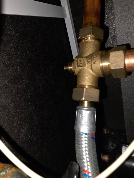 Ventil med LK-logotyp ansluten till kopparrör och slang.